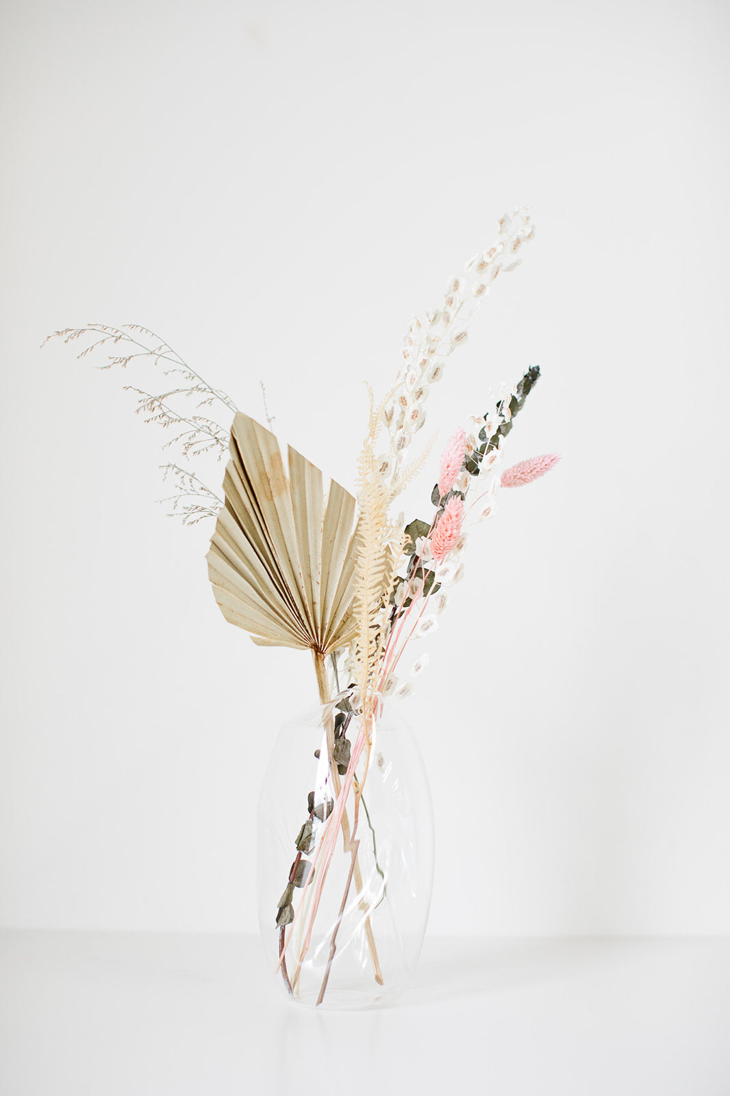 Selection of pastel coloured flowers in a mason jar vase